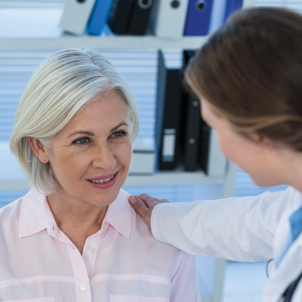 Audiologist reassuring an active patient during a hearing‑aid consultation, highlighting the importance of personalized fittings for lifestyle needs.
