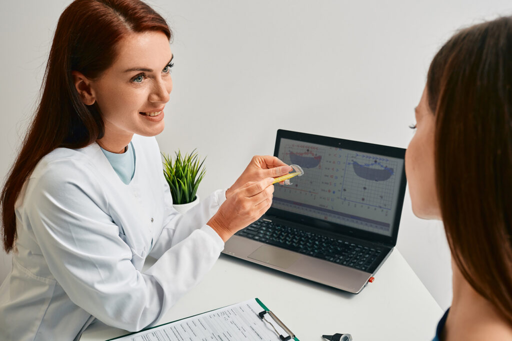 Audiologist showing hearing aids to patient